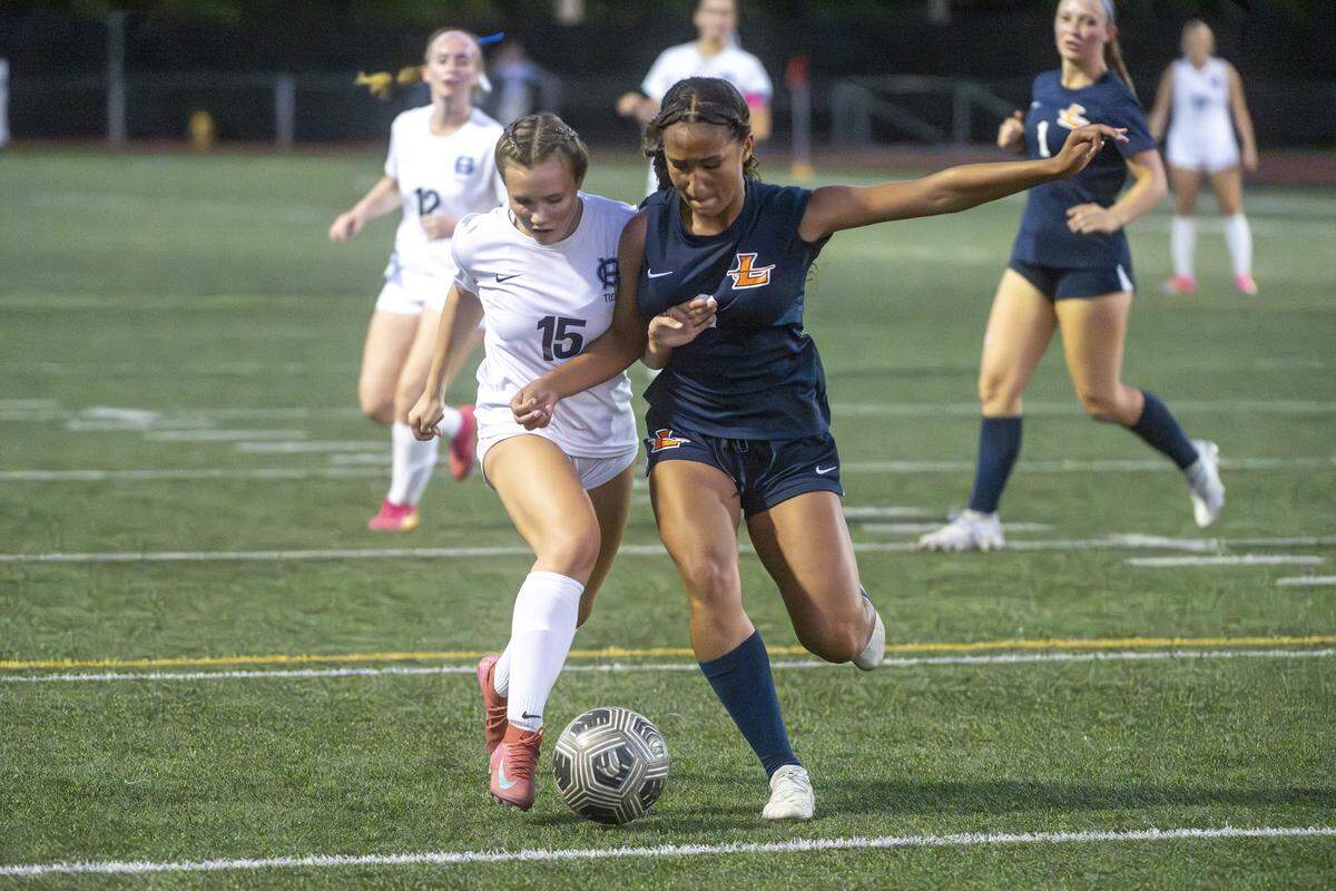 Gig Harbor junior Janelle Jones (15) and Lakes freshman Brooklynn Turner (6) fight for control of the ball during a game on Tuesday, Sept. 16, 2025, in Lakewood, Wash. Jones pushed past Turner to score a goal.