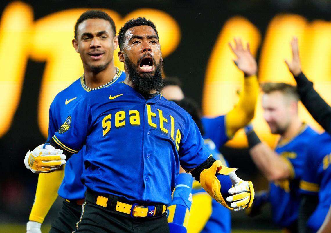 Seattle Mariners’ Teoscar Hernandez, second from left, celebrates hitting a walk-off single for a 3-2 win over the Toronto Blue Jays as teammate Julio Rodriguez, left, looks on after a baseball game, Friday, July 21, 2023, in Seattle. (AP Photo/Lindsey Wasson)