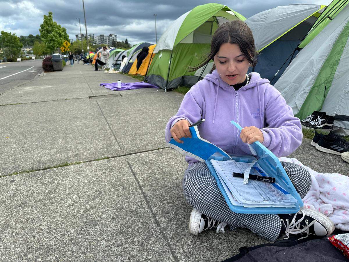 Lauren Tibbett, 23, of Yakima keeps the unofficial roster of campers Monday who will be the first enter the Tacoma Dome Tuesday to see K-pop sensation Tomorrow X Together.