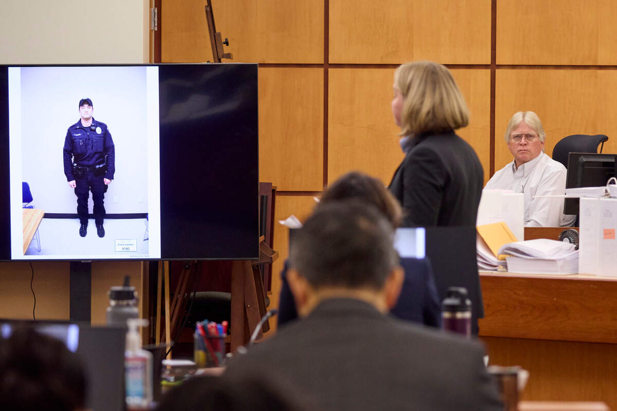 Lori Nicolavo from the Washington State Attorney General’s office, center, questions former forensics investigator Steve Wilkins, seated back right, about the photos he took of officers during the trial of Tacoma Police officers accused in the death of Manny Ellis held at Pierce County Superior Court, Thursday, Oct. 19, 2023, in Tacoma, Wash. Officers Christopher Burbank, Matthew Collins and Timothy Rankine are charged. (John Froschauer/Pool Photo AP)
