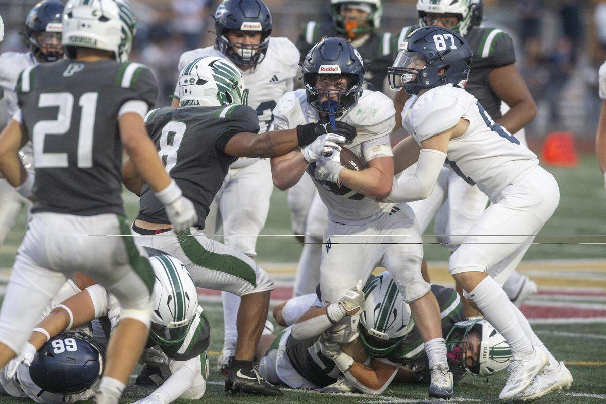 Gig Harbor running back Ian Shearer (8), center, pulls against several Peninsula defenders during the Fish Bowl on Saturday, Sept. 6, 2025, at Mount Tahoma Stadium in Tacoma, Wash.