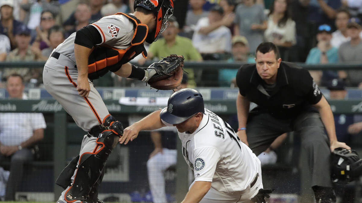 Seattle Mariners' Kyle Seager is tagged out at home by San Francisco Giants catcher Buster Posey as he tried to score on a single by Mike Zunino during the fourth inning of a baseball game Tuesday, July 24, 2018, in Seattle. (AP Photo/Ted S. Warren)