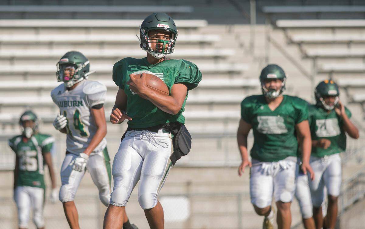 Auburn High School quarterback Amari Goodfellow (center) runs with the ball during a scrimmage period at practice on Tuesday, Aug. 23, 2022 in Auburn, Wash.