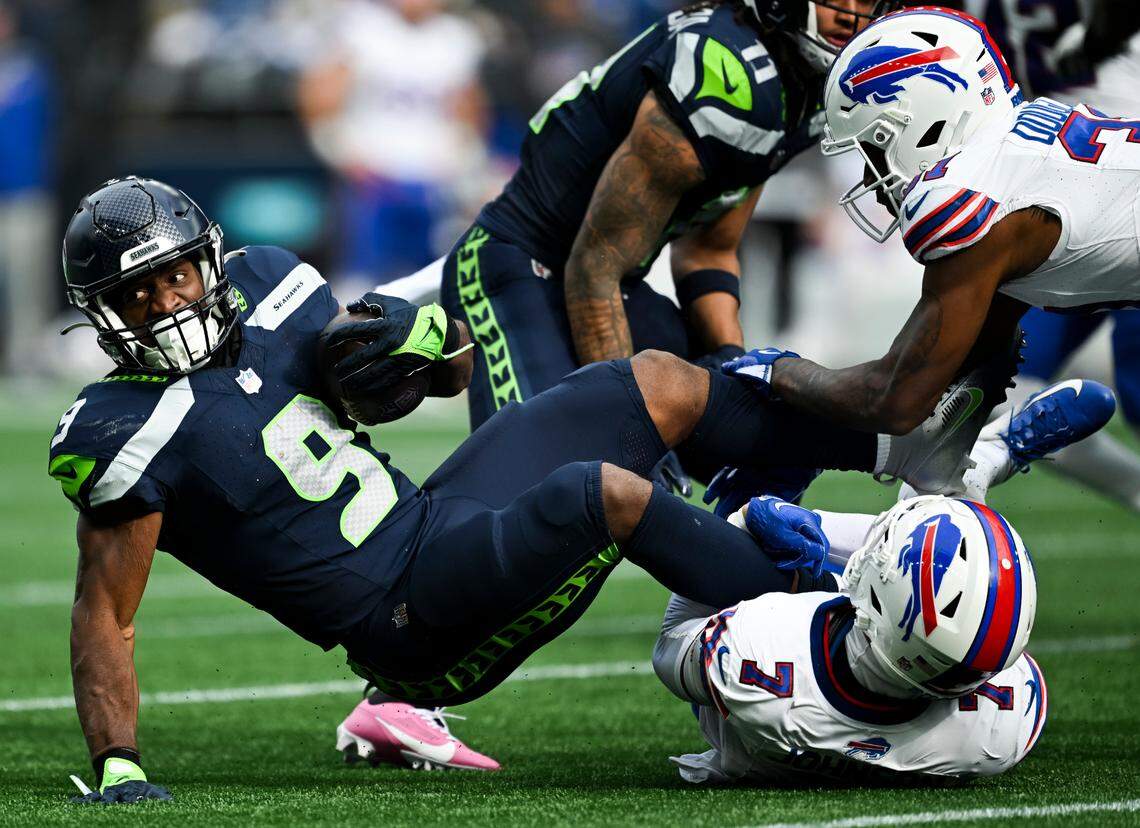 Seattle Seahawks running back Kenneth Walker III (9) is tripped up by Buffalo Bills cornerback Taron Johnson (7) during the first quarter of the game at Lumen Field, on Sunday, Oct. 27, 2024 in Seattle, Wash.