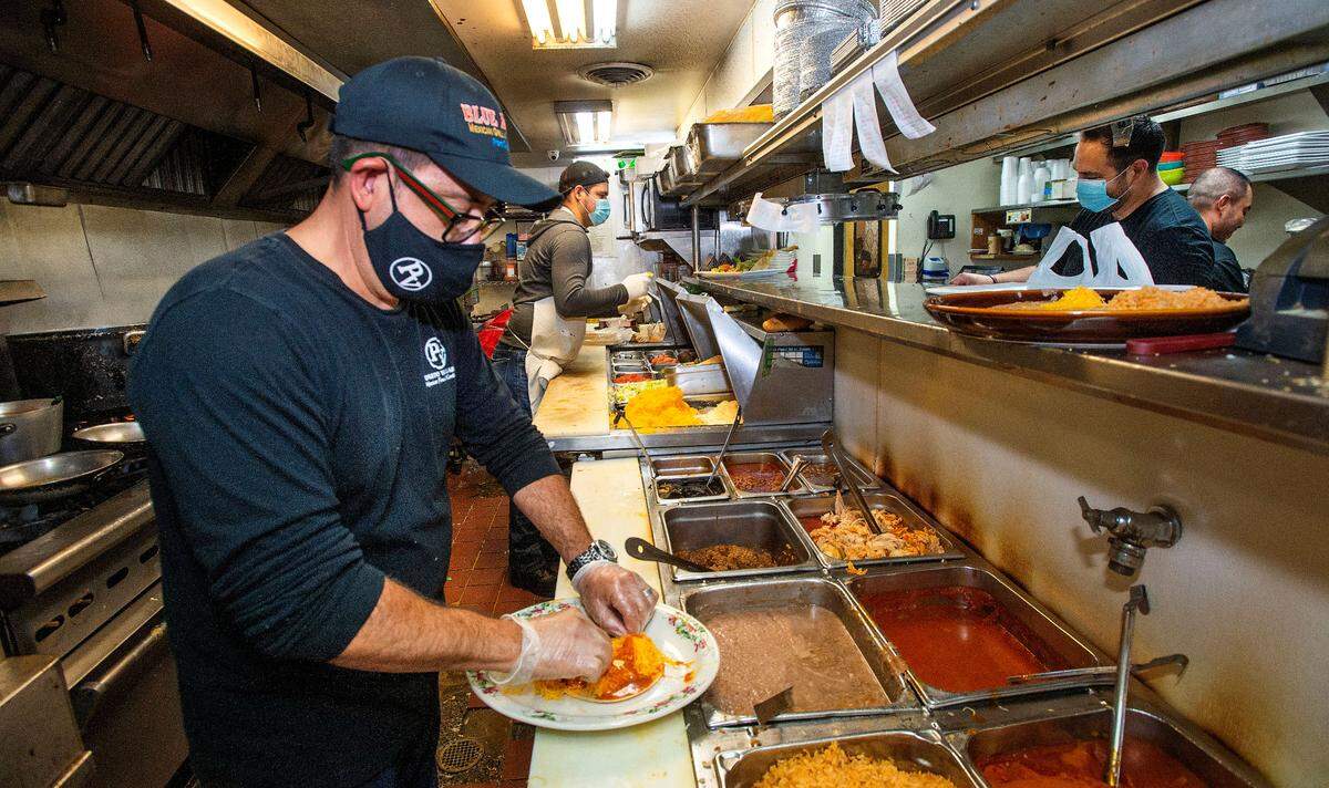 Sergio Andrade, co-owner and manager of Puerto Vallarta in Gig Harbor, plates an order in the kitchen Sunday, August, 15, 2021. It’s not his normal role but the restaurant, like many other local businesses, has been experiencing a staffing shortage since the state reopened. “It’s been a struggle,” said Andrade. “All my friends in the business are in the same boat. We’re all suffering.”