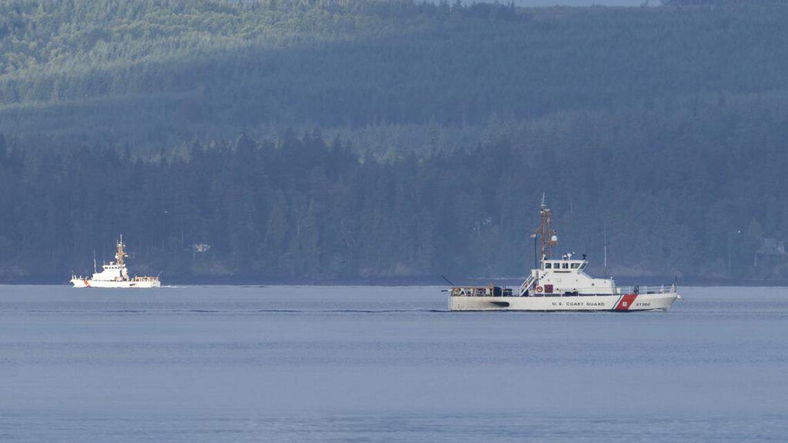 A pair of U.S. Coast Guard vessels searches the area, Monday, Sept. 5, 2022, near Freeland, Washington, on Whidbey Island north of Seattle where a chartered floatplane crashed the day before. The plane was carrying 10 people and was en route from Friday Harbo to Renton.