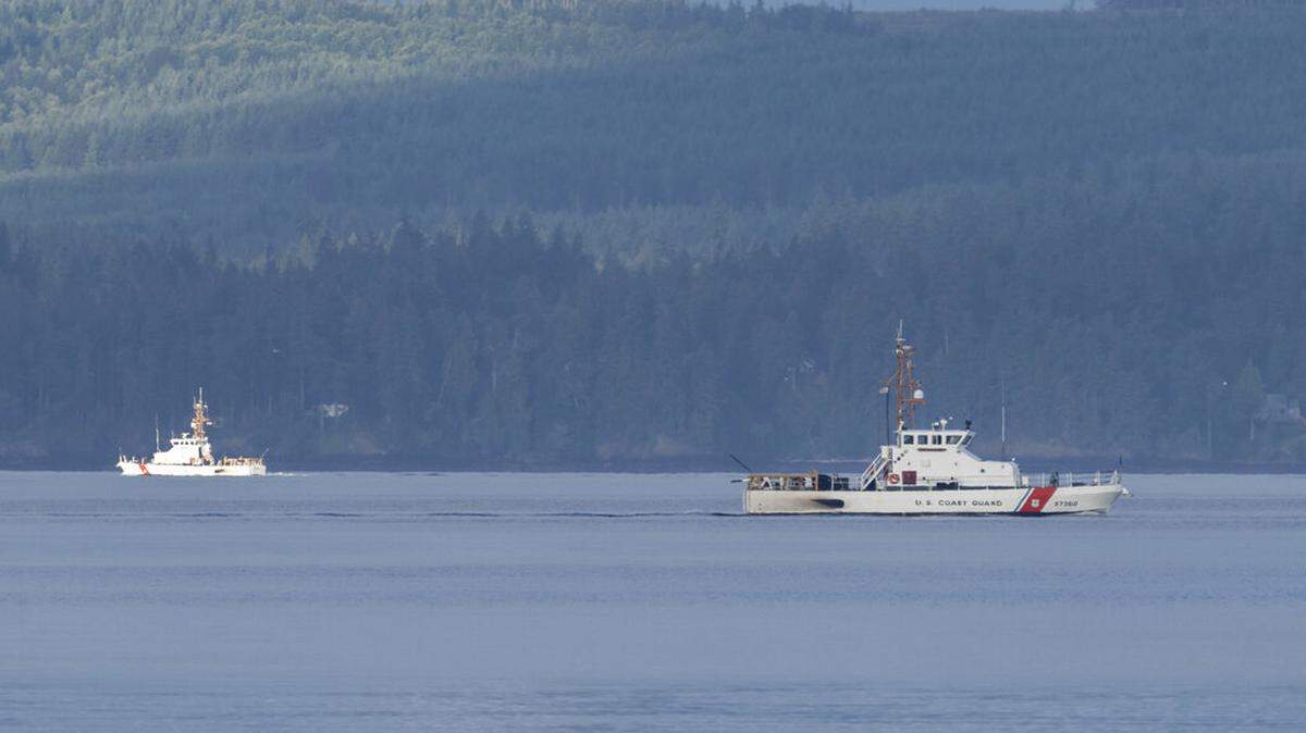A pair of U.S. Coast Guard vessels searches the area, Monday, Sept. 5, 2022, near Freeland, Washington, on Whidbey Island north of Seattle where a chartered floatplane crashed the day before. The plane was carrying 10 people and was en route from Friday Harbo to Renton.