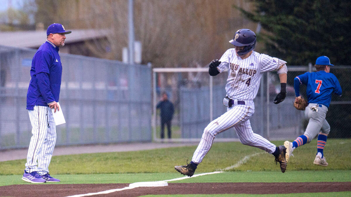 Puyallup head coach Marc Wiese watches from third base as Gage Thompson rounds third base for an inside-the-park home run during a 4A South Puget Sound League game against Graham-Kapowsin on Tuesday, May 3, 2022, at Heritage Park in Puyallup.