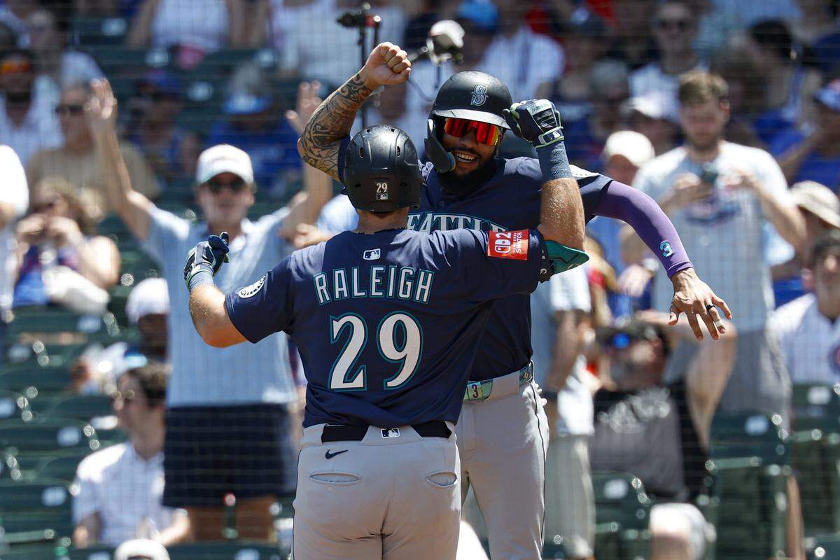 Jun 22, 2025; Chicago, Illinois, USA; Seattle Mariners designated hitter Cal Raleigh (29) celebrates with shortstop J.P. Crawford (3) after hitting a two-run home run against the Chicago Cubs during the first inning at Wrigley Field. Mandatory Credit: Kamil Krzaczynski-Imagn Images