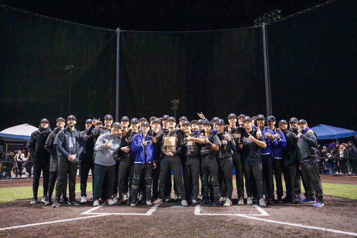 Puyallup poses with their 4A District Championship after their win over Sumner on Saturday, May 17, 2025, at Tahoma High School in Maple Valley, Wash.