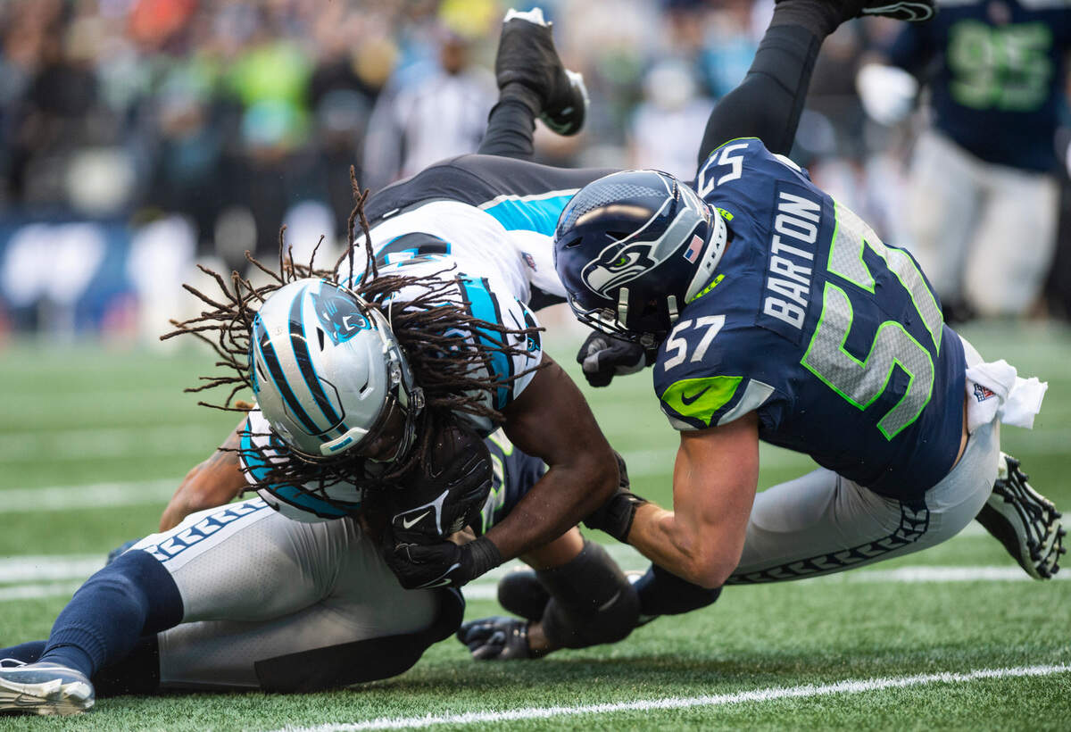 Seattle Seahawks linebacker Cody Barton (57) and Seattle Seahawks safety Ryan Neal (26) collide with Carolina Panthers tight end Ian Thomas (80) while trying to tackle Thomas in the first quarter of an NFL game at Lumen Field in Seattle Wash., on Dec. 11, 2022.