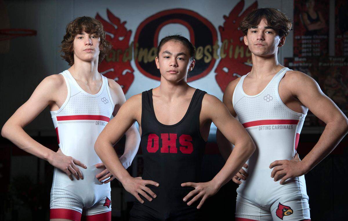 Orting wrestlers Quentin Harding (from left), Apollo Cruz and Owen Cline are leading the Cardinals. They are shown before wrestling practice at Orting High School in Orting, Washington, on Friday, Jan. 28, 2022.