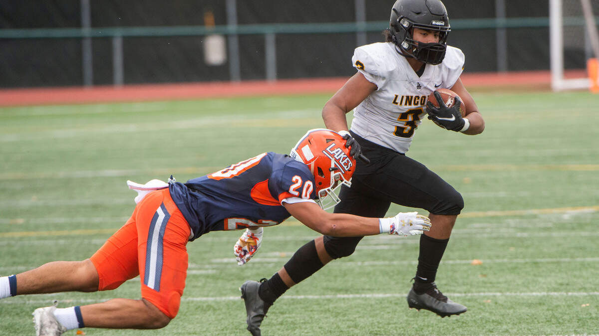 Lincoln running back Navarre Dion avoids being tackle by Lakes linebacker Leo Pulalasi in a 3A Pierce County League football game at Harry Lang Stadium in Lakewood on Saturday, Oct. 23, 2021.