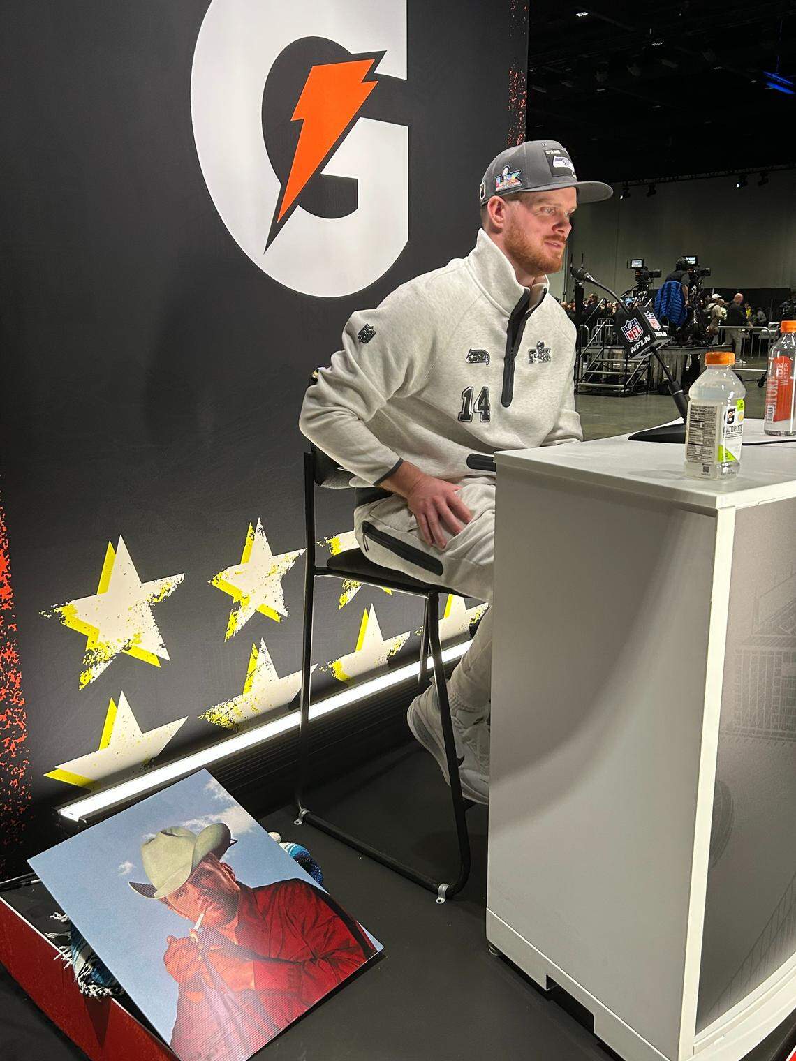 Sam Darnold next to the Marlboro Man (his grandfather, Dick Hammer) poster superimposed with the Seahawks quarterback’s face, at the Super Bowl Opening Night media event at the San Jose (Calif.) Convention Center Monday, Feb. 2, 2026.