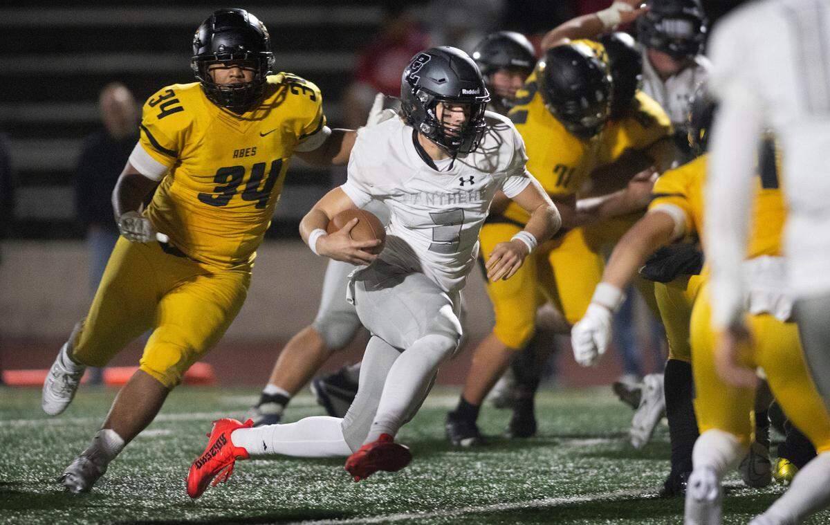 Bonney Lake quarterback Brayden Palmer scrambles in front of Lincoln defensive lineman Kelly Sio-Fetaui during Thursday night’s football game at Lincoln Bowl in Tacoma, Washington, on Sept. 28, 2023. Lincoln won the game, 42-28.
