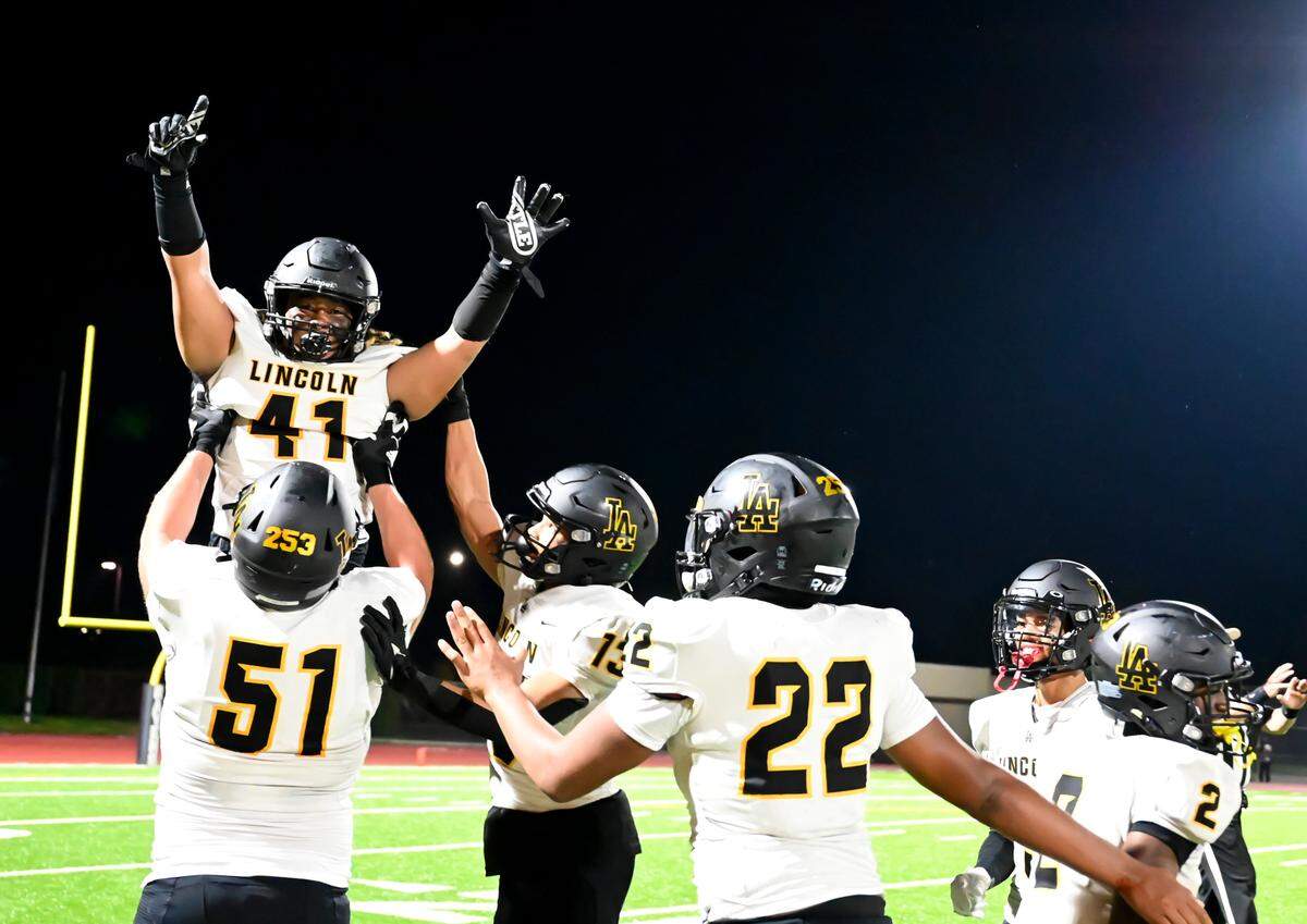 Lincoln’s Brian Gatewood (41) is lifted up by Brad Amsden (51) after a big block on a punt return during the second half of the high school football game at Auburn Memorial Stadium, Friday, Sept. 1, 2023, Auburn, Wash.