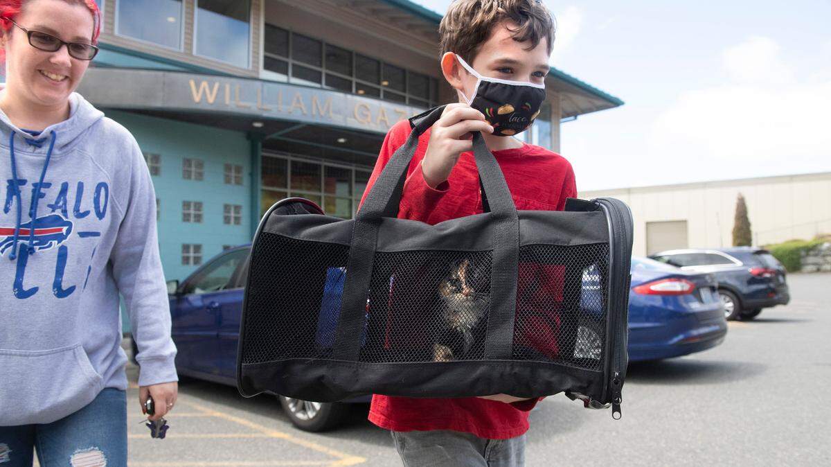 Garrett West, 10, of Port Orchard, carries his family’s new kitten he and his mom, Kassandra West, adopted from the Humane Society for Tacoma & Pierce County in Tacoma, Washington, on Wednesday, July 7, 2021.