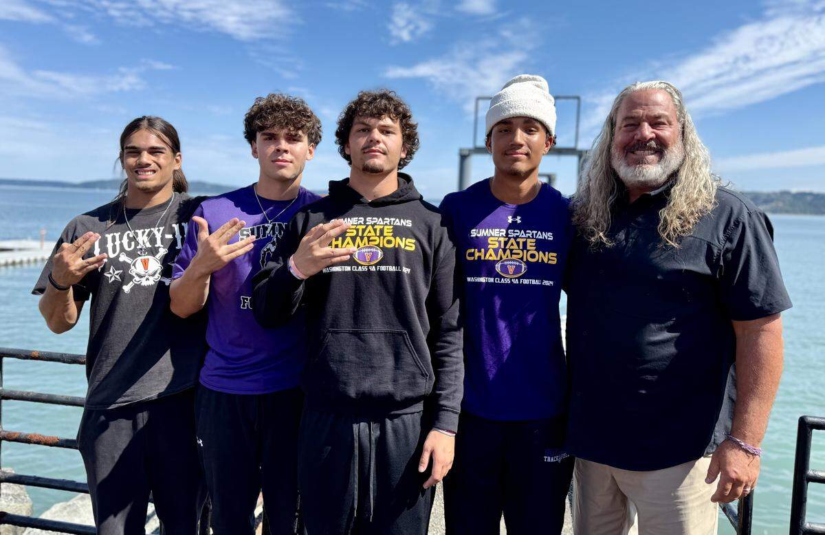 From left, Sumner High School’s Elias Isaacs, Nate Donovan, Austin Glivar, Braylon Pope and coach Keith Ross, the defending 4A state champions, at the 4A South Puget Sound League football Media Day at The Ram Restaurant on Ruston Way on Tuesday, Aug. 19, 2025.