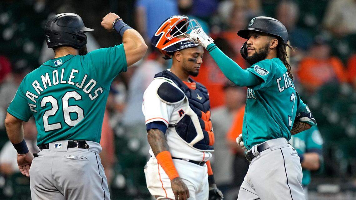 Seattle Mariners’ J.P. Crawford (3) celebrates with Jose Marmolejos (26) after both scored on Crawford’s two-run home run as Houston Astros catcher Martin Maldonado looks down during the ninth inning of a baseball game Wednesday, Sept. 8, 2021, in Houston. (AP Photo/David J. Phillip)