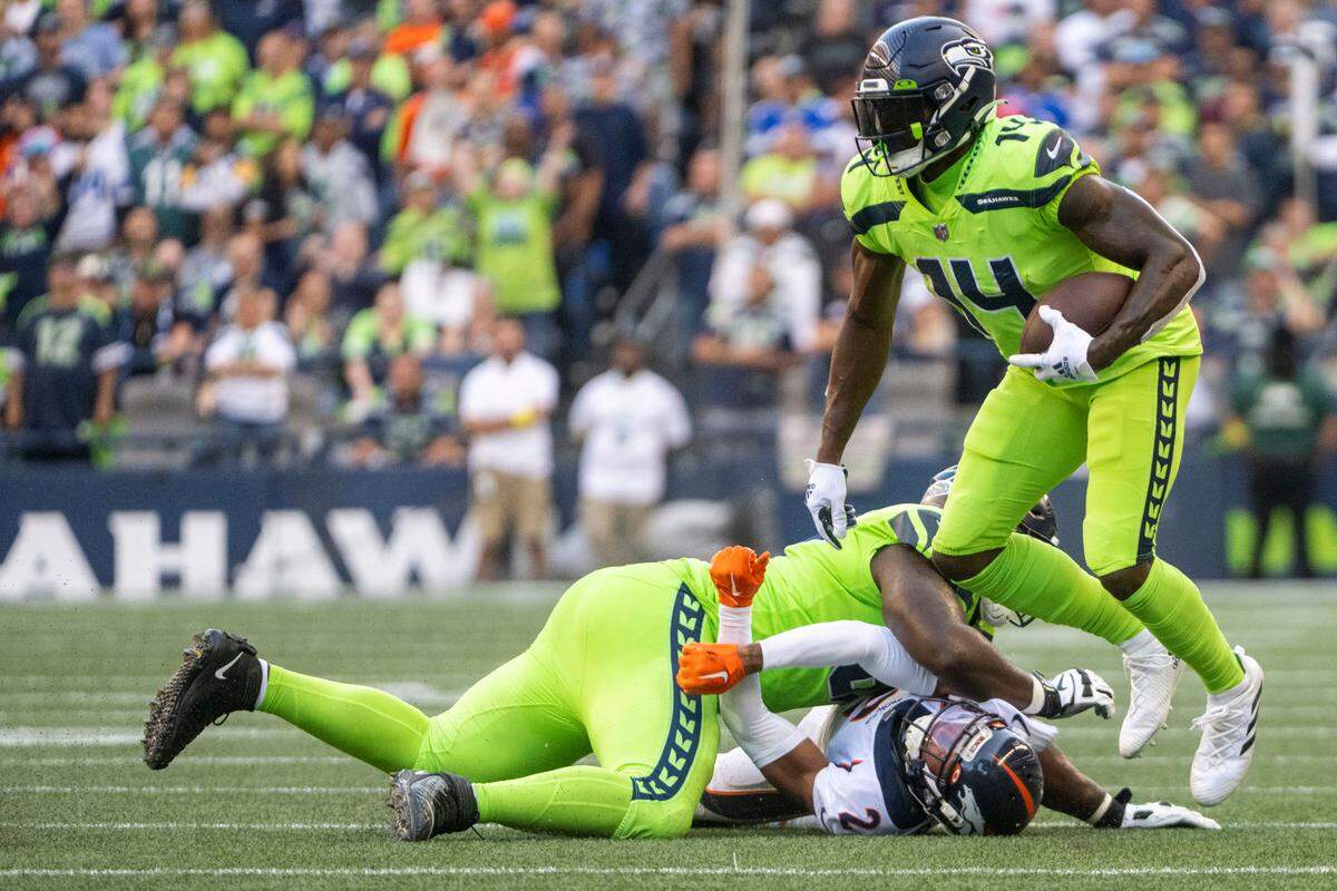 After catching a pass from quarterback Geno Smith (7), wide receiver DK Metcalf (14) looks to gain yards up the field during the second quarter of an NFL game on Monday, Sept. 12, 2022, at Lumen Field in Seattle.