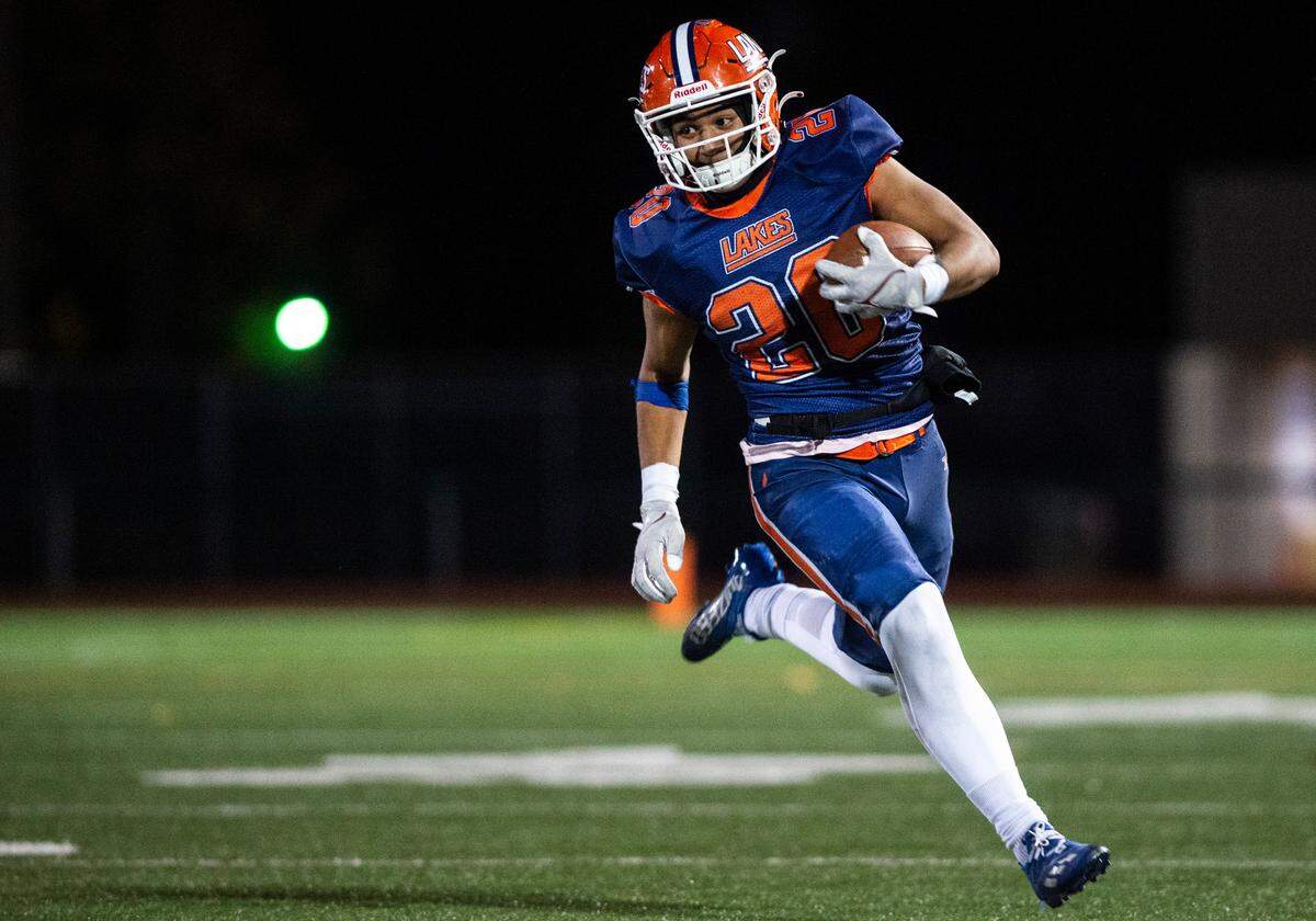 Lakes running back Leo Pulalasi, 20, runs down the field with the ball in the second quarter of a Thursday night game at Harry E. Lang Stadium in Lakewood, Wash. on Oct. 27, 2022. Lakes defeated Mount Tahoma 51-14.