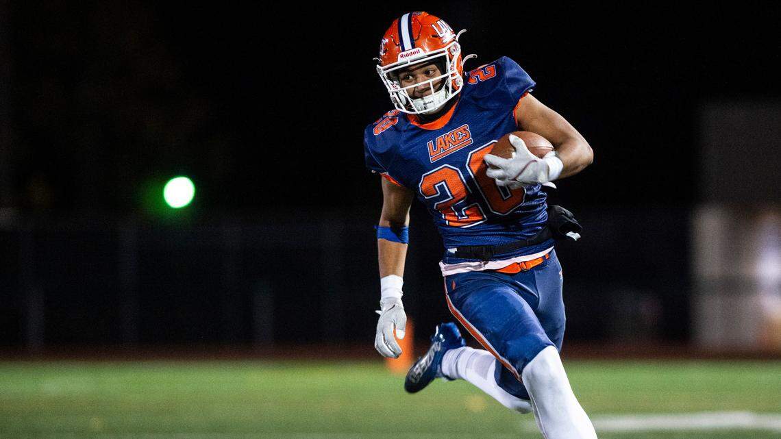 Lakes running back Leo Pulalasi, 20, runs down the field with the ball in the second quarter of a game at Harry E. Lang Stadium in Lakewood on Oct. 27, 2022. Lakes defeated Mount Tahoma 51-14.