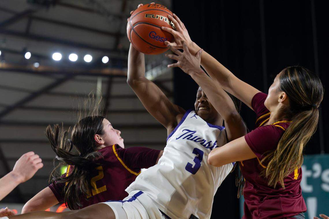 North Thurston guard Soraya Ogaldez (3) grabs a rebound between Lakeside guard Helena Christofilis (12) and Lili Brown (24) during the first quarter of a Class 3A state basketball tournament semifinal game at the Tacoma Dome on Friday, March 7, 2025, in Tacoma, Wash.
