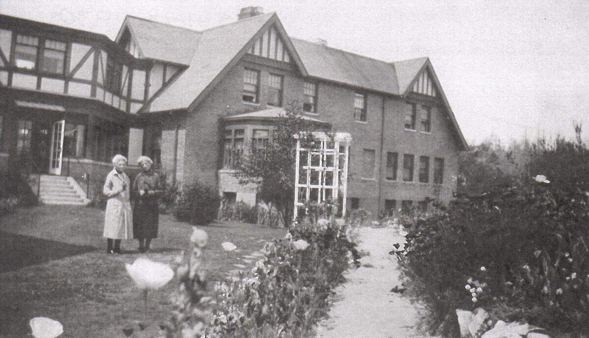 Two women stand in the gardens of Franke Tobey Jones in the 1930s.