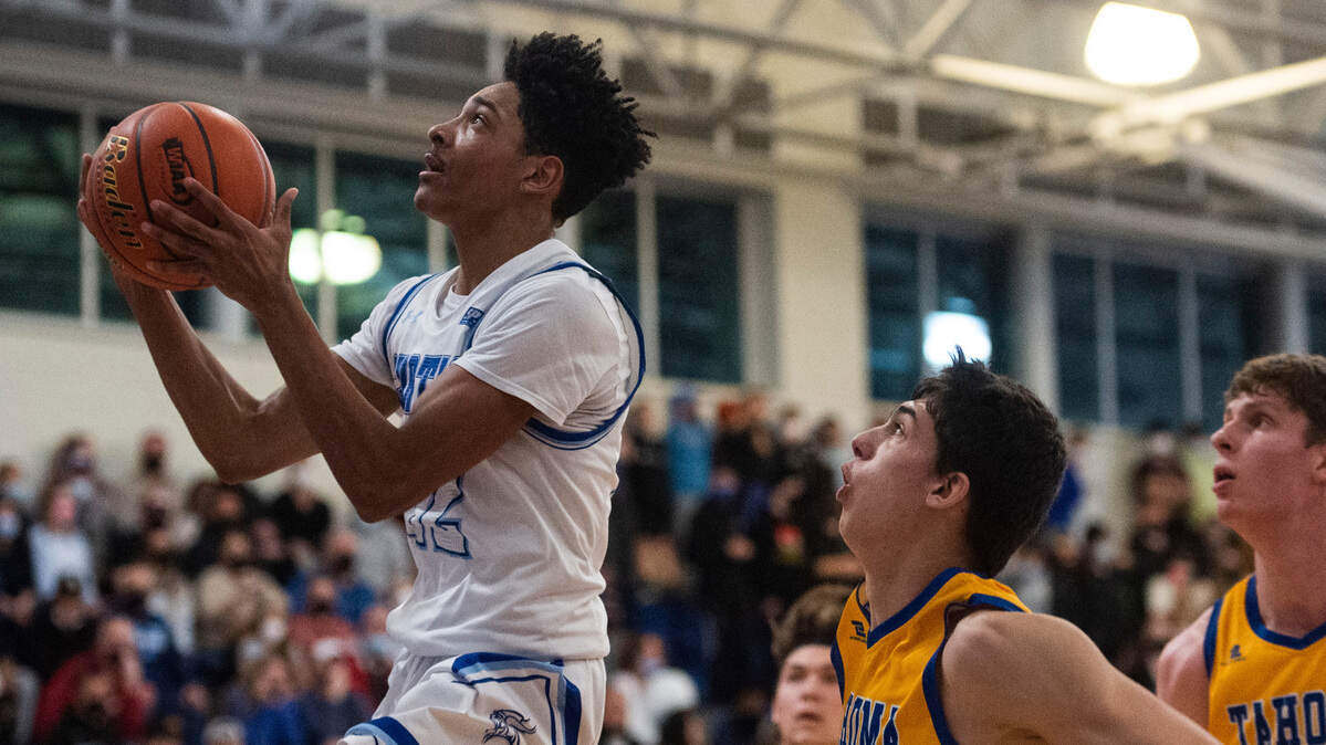 Curtis’s guard Cinque Maxwell (12) goes in to make a basket during the 4A District 3/4 high school boys basketball championship game at the Curtis High School on Saturday, Feb. 19, 2022, in University Place, Wash.