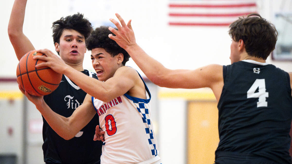 Auburn Mountainview’s Kolven Posey (0) goes the basket against two Gig Harbor Tides defenders during the second half of the 3A District 3/4 tournament boys semifinal on Tuesday, Feb. 18, 2025, in Tacoma, Wash. 