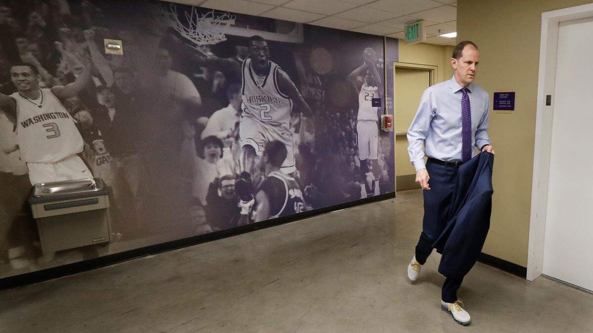 In this Sunday, Jan. 28, 2018 photo, Washington head coach Mike Hopkins walks through a hallway in Hec Edmundson Pavilion less than an hour before tip-off of an NCAA college basketball game against Washington State in Seattle. Behind him are photos of Washington standouts Brandon Roy, left, who played for the Portland Trailblazers and the Minnesota Timberwolves, Nate Robinson, center, who played for the New York Nicks and several other NBA teams, and C.J. Wilcox, right, who played for the Los Angeles Clippers and the Orlando Magic. One of the most surprising stories in college basketball is what Hopkins is doing in his first season at Washington and how the Huskies are in the conversation for an NCAA bid entering February. (AP Photo/Ted S. Warren)