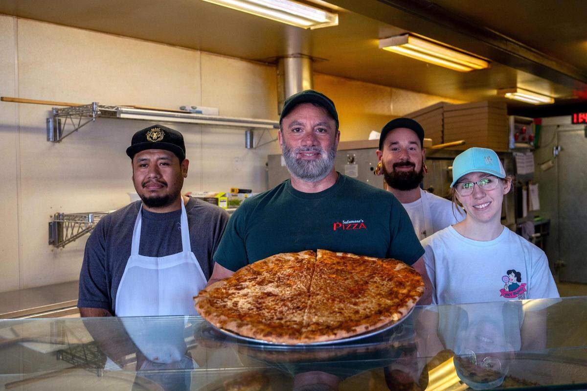 Steven Salamone (middle) with employees (left to right) Jesus Rios, Geoff Scarfo and Candace Holland at the Stadium District pizzeria on Wednesday June 29, 2022.
