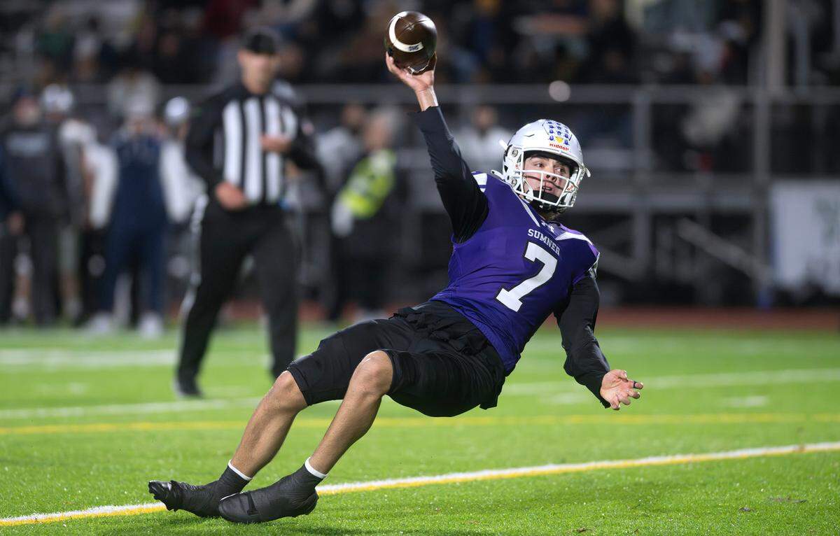Sumner quarterback Nate Donovan stumbles as he fires a pass for a two-point conversion during Saturday’s 4A state football semifinal game against the Chiawana Riverhawks at Sunset Chev Stadium in Sumner, Washington, on Nov. 30, 2024. Sumner won the game, 37-31 in triple overtime, to advance to next weekend’s state championship game at Husky Stadium in Seattle.