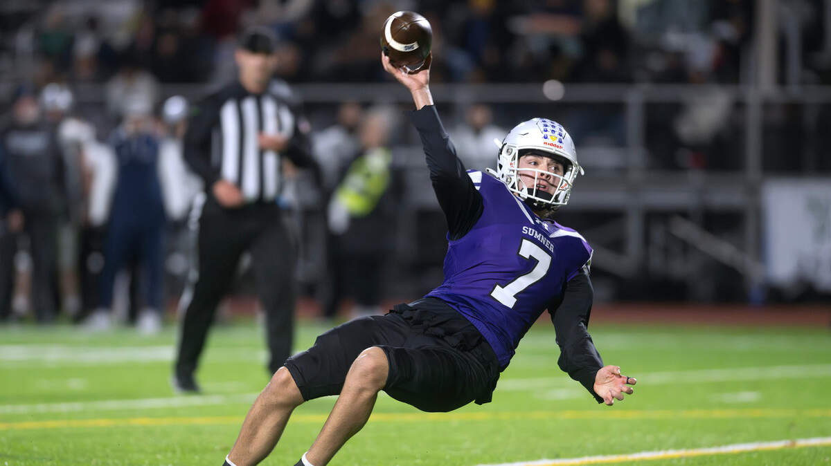 Sumner quarterback Nate Donovan stumbles as he fires a pass for a two-point conversion during Saturday’s 4A state football semifinal game against the Chiawana Riverhawks at Sunset Chev Stadium in Sumner, Washington, on Nov. 30, 2024. Sumner won the game, 37-31 in triple overtime, to advance to next weekend’s state championship game at Husky Stadium in Seattle.