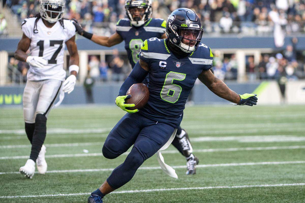 Seattle Seahawks safety Quandre Diggs (6) runs back an interception by Las Vegas Raiders quarterback Derek Carr (4) during the first quarter of an NFL game on Sunday, Nov. 27, 2022, at Lumen Field in Seattle.