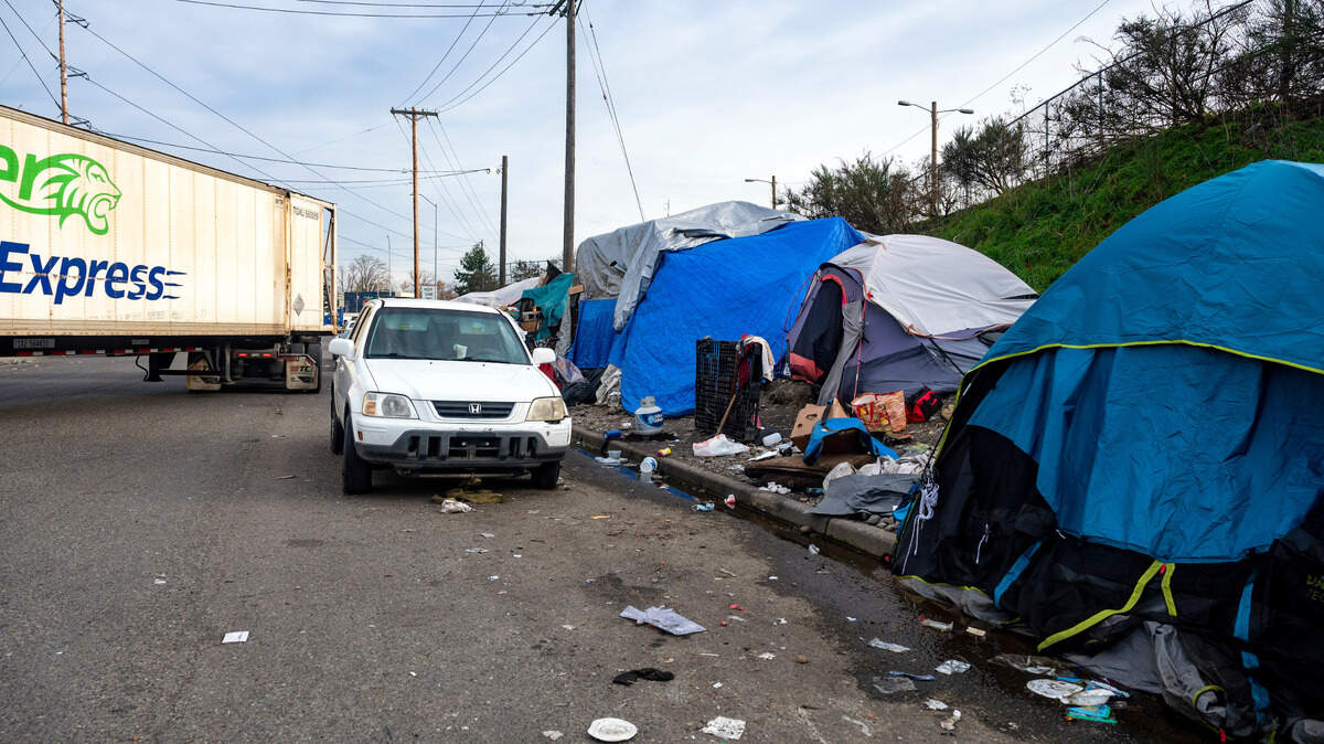 A truck pulls out of a the south end of the Pilot Express gas station onto East 25th Street and where there are over 20 tents housing displaced people on Friday afternoon in Tacoma. Sound Transit, who owns the property where people are encamped, informed them on Friday that there will be cleaning up the area on Dec. 17 and they would have to move all their belongings by then.