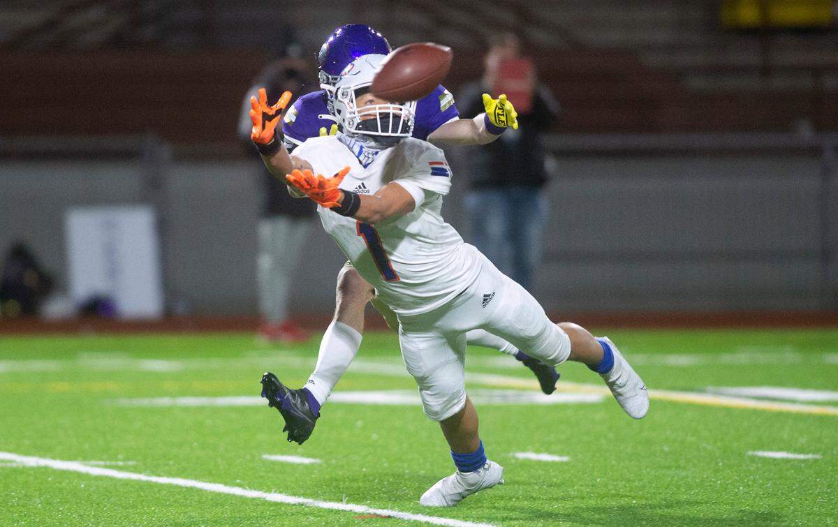 Graham-Kapowsin wide receiver Julian Mason lays out to pull in a fourth-down pass from quarterback Joshua Wood in front of Puyallup defensive back Chance Bartelson during Thursday night’s football game at Sparks Stadium in Puyallup, Washington, on March 11, 2021.