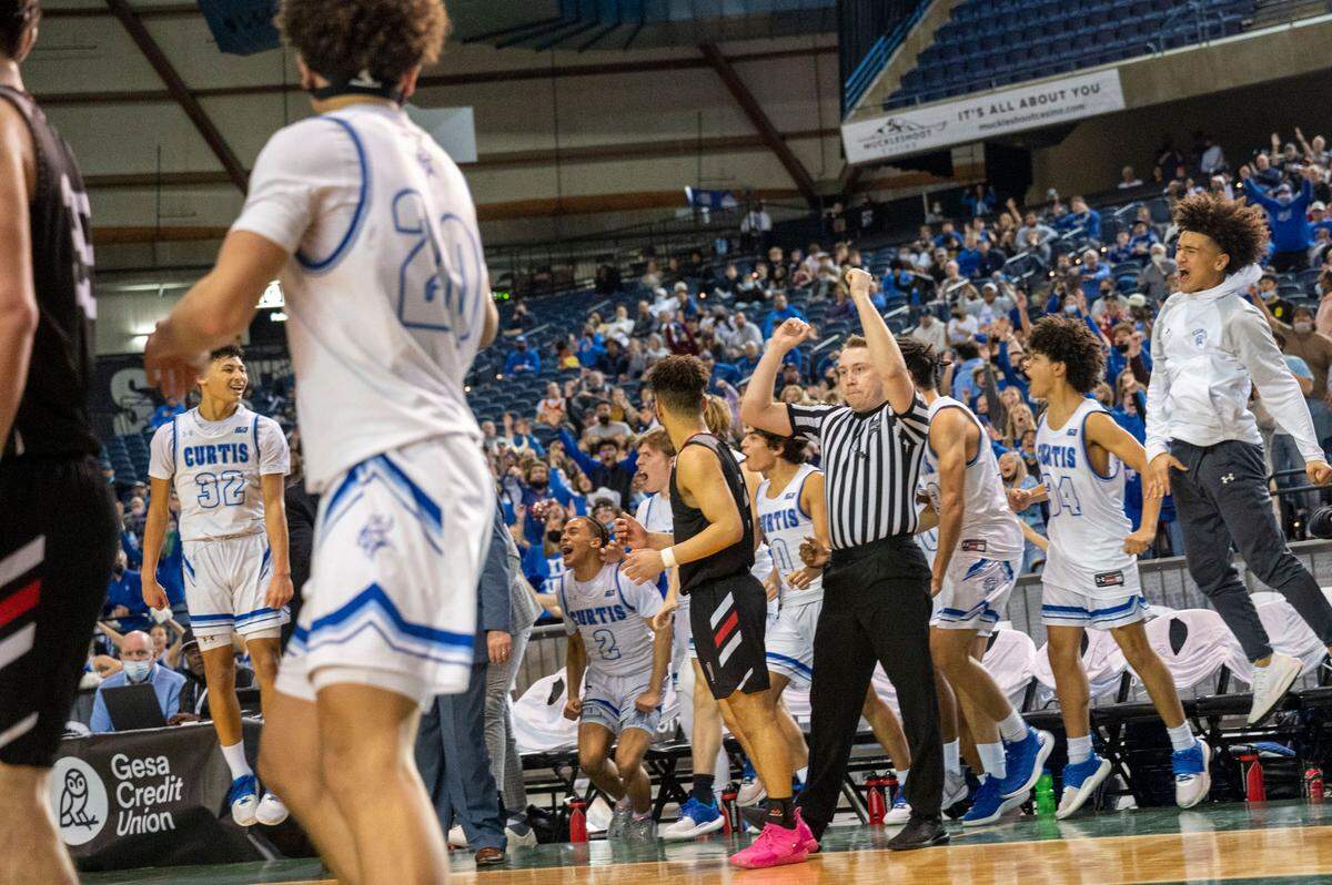 Curtis guard Devin Whitten (32) celebrates after sinking a 3-pointer while getting fouled as his bench joins in on the jubilation as Union guard Jamison Limbrick (2) looks on during the fourth quarter of a Class 4A state tournament semifinal game on Friday, March 4, 2022, at the Tacoma Dome, in Tacoma, Wash. Whitten’s 3-pointer helped put the game out of reach.