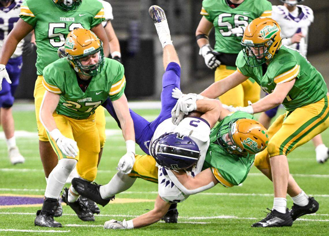 Anacortes’s Brady Beaner (2) is tackled by Tumwater’s Cash Short (23) during the second half of the 2A state championship game at Husky Field, Saturday, Dec. 2, 2023, in Seattle, Wash.