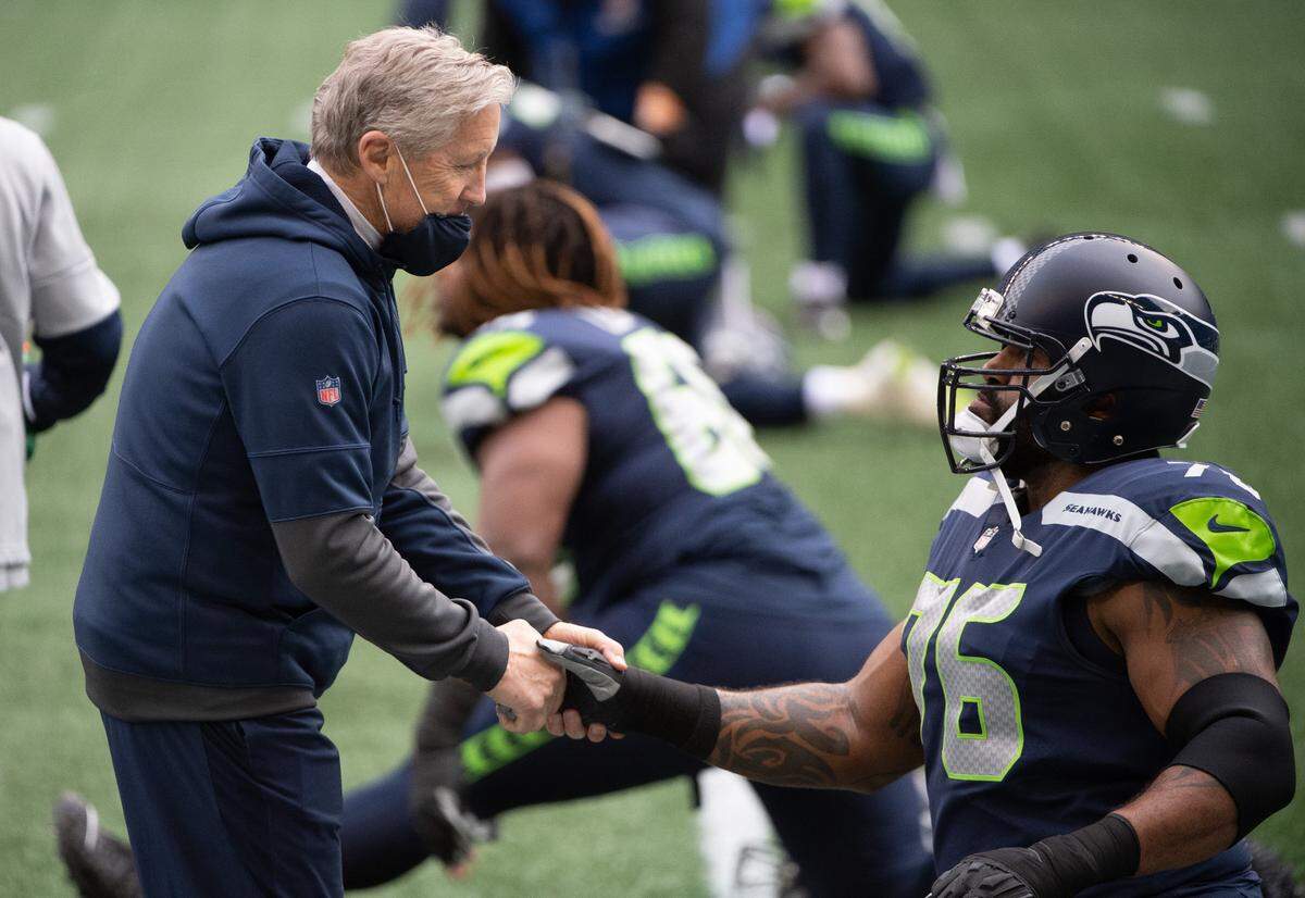 Head coach Pete Carroll and Seattle Seahawks offensive lineman Duane Brown meet before the game. The Seattle Seahawks played the Los Angeles Rams in a NFL football game at Lumen Field in Seattle, Wash., on Sunday, Dec. 27, 2020.