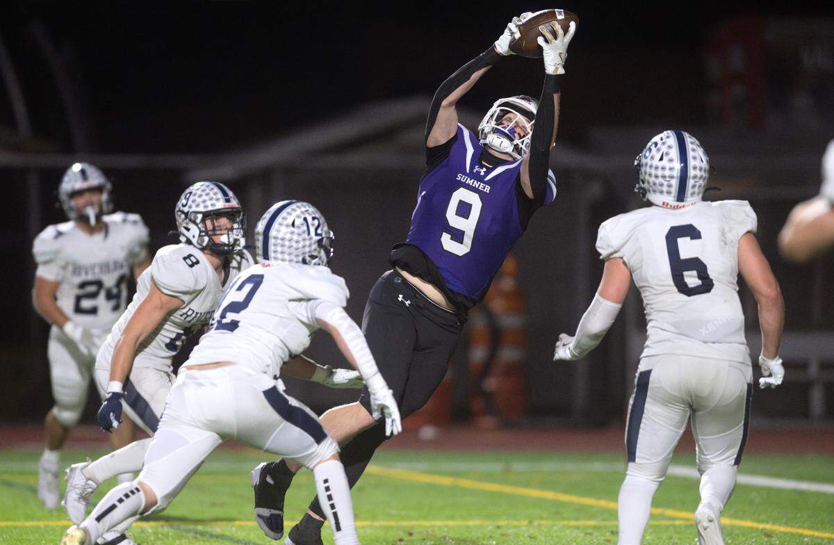 Sumner tight end Carter Cocke pulls down a touchdown reception over Chiawana defenders Brooks Zaro (8), Morgan Dodson (2) and Braxton Feldmann during Saturday’s 4A state football semifinal game at Sunset Chev Stadium in Sumner, Washington, on Nov. 30, 2024. Sumner won the game, 37-31 in triple overtime, to advance to next weekend’s state championship game at Husky Stadium in Seattle.