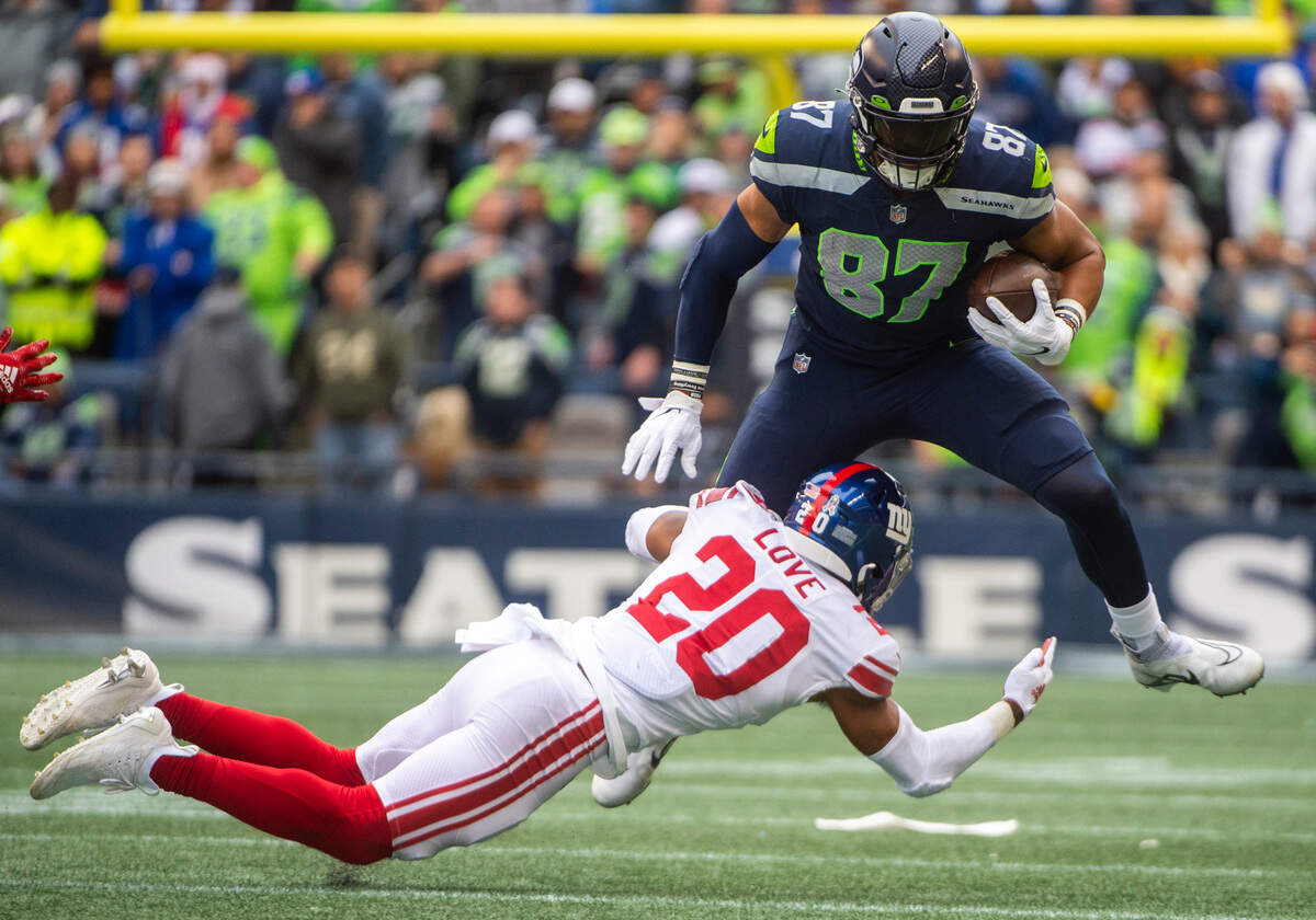 Seattle Seahawks tight end Noah Fant (87) jumps over New York Giants safety Julian Love (20) while running down the field with the ball in the first quarter of an NFL game at Lumen Field in Seattle, Wash. on Oct. 30, 2022. The Seahawks defeated the Giants 27-13.