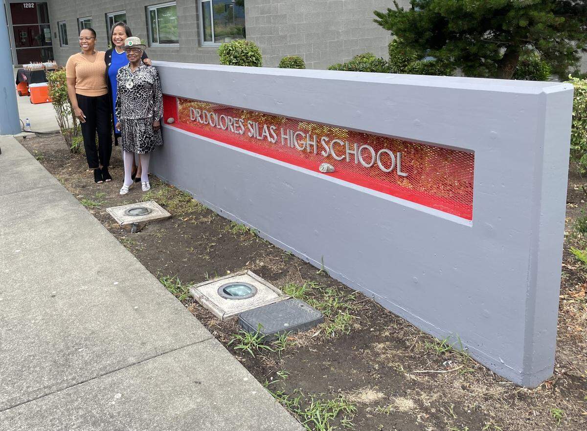 Tacoma Public Schools Board Director Andrea Cobb, Tacoma Mayor Victoria Woodards and Dr. Dolores Silas stand for a picture in front of the newly-named Dolores Silas High School.