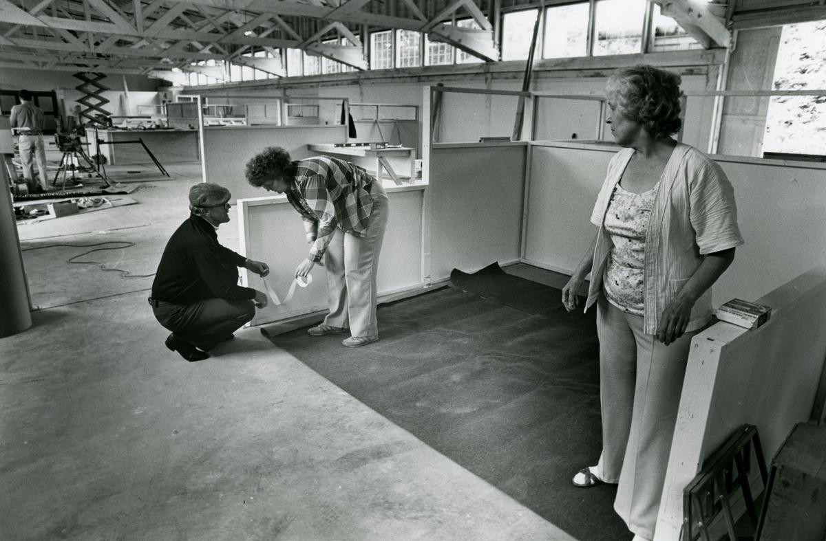 Merchants get ready to open their businesses in the newly remodeled Freighthouse Square in 1987. Pictured is the proprieters of Rainbow's End setting up their booth. Right is Claire Bliss watching her daughter Marlene Morris and her husband Kenneth Bliss prepare to lay down the carpet.