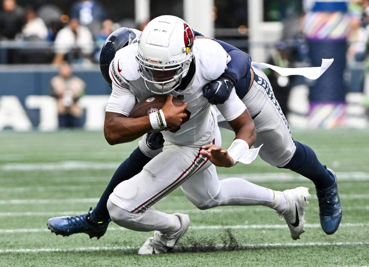 Arizona Cardinals quarterback Joshua Dobbs (9) is tackled by Seattle Seahawks linebacker Jordyn Brooks (56) during the fourth quarter of the game at Lumen Field, Sunday, Oct. 22, 2023, in Seattle, Wash.