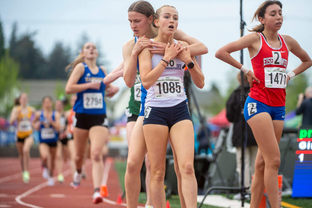 Curtis’ Eliza White hugs Bellarmine Prep’s Ella Borsheim after Borsheim edged White by less than a second to win the girls 4A 1600-meters title at the State 2A, 3A, 4A track and field championships on Thursday, May 26, 2022, at Mount Tahoma High School in Tacoma Wash.