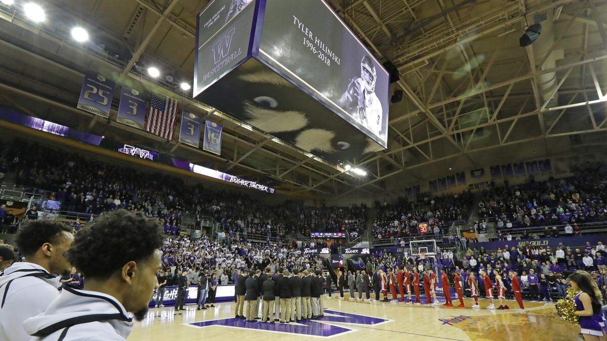 Washington and Washington State players and coaches join the crowd in a moment of silence, Sunday, Jan. 28, 2018, before an NCAA college basketball game in Seattle, in memory of Washington State football quarterback Tyler Hilinski, who police said committed suicide Jan. 16, 2018, in his apartment in Pullman, Wash.