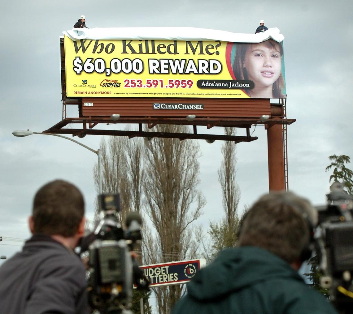 Workers unveil a Crime Stoppers billboard prominently featuring Adre'anna Jackson's photo on Monday, March 26, 2007, at the corner of Union Avenue and Center Street in Tacoma. The billboard was part of a media partnership to solicit information to help find Jackson's killer.