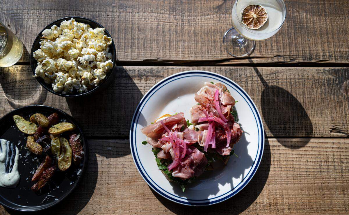 Hearty plates on house focaccia include a couple of sandwiches, pimento cheese and this prosciutto toast with pickled onions, whipped ricotta and arugula.