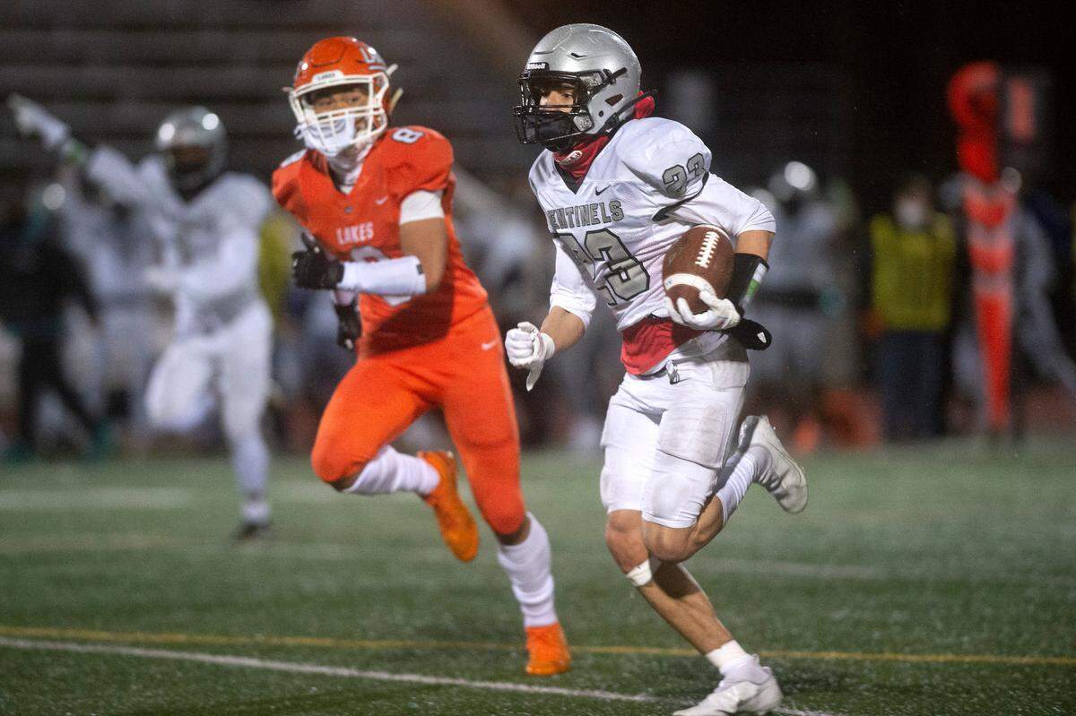 Spanaway Lake running back Jasiah Wagoner breaks loose in front of Lakes defensive back Aslan Fraser for a 60-yard touchdown run during Wednesday night’s high school football game at Harry Lang Stadium in Lakewood, Washington, on March 24, 2021.
